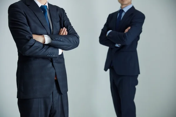 腕を組む二人の男性