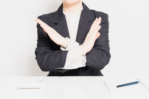 手で×を示す女性